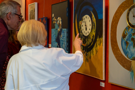 Person im Vordergrund zeigt auf Bild in der Ausstellung