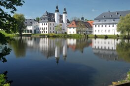 Auf dem Bild das Gebäude des Deutschen Landwirtschaftsmuseum im Sommer, im Vordergrund ein Teich