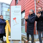 Feierliche Enth&uuml;llung des Schildes mit dem neuen Namen vor der Schule